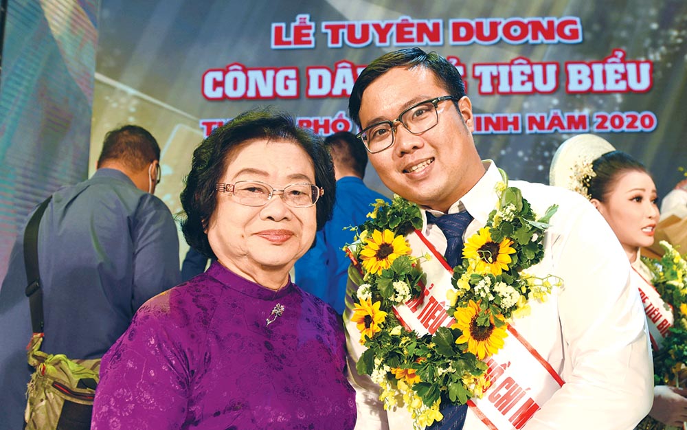Phan Minh Tiến (bên phải) chụp ảnh cùng nguyên Phó chủ tịch nước Trương Mỹ Hoa tại Lễ tuyên dương công dân trẻ tiêu biểu TP.HCM 2020