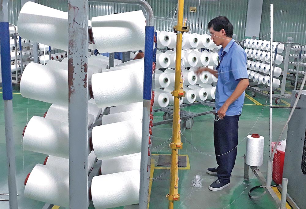 doanh nghiệp dệt may đang tăng cường đầu tư để tận dụng ưu đãi từ các FTA. Trong ảnh: Sản xuất tại Công ty cổ phần Sợi Thế Kỷ