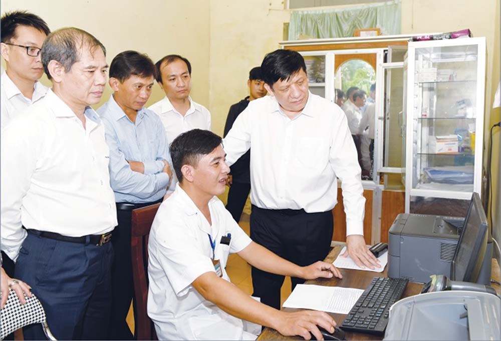 Bộ trưởng Bộ Y tế Nguyễn Thanh Long kiểm tra việc quản lý hồ sơ sức khỏe tại Trạm y tế xã Hương Long (Hà Tĩnh) 	ảnh: từ thành