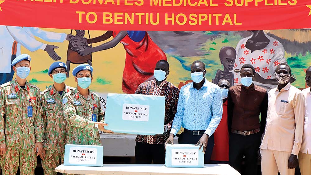 Bệnh viện dã chiến cấp 2 số 3 của Việt Nam tặng thuốc men, sát khuẩn tay cho Bệnh viện Bentiu (Nam Sudan) trong đợt lũ lụt nặng nề nhất 60 năm qua tại đây  	Ảnh: Cục gìn giữ hòa bình việt nam