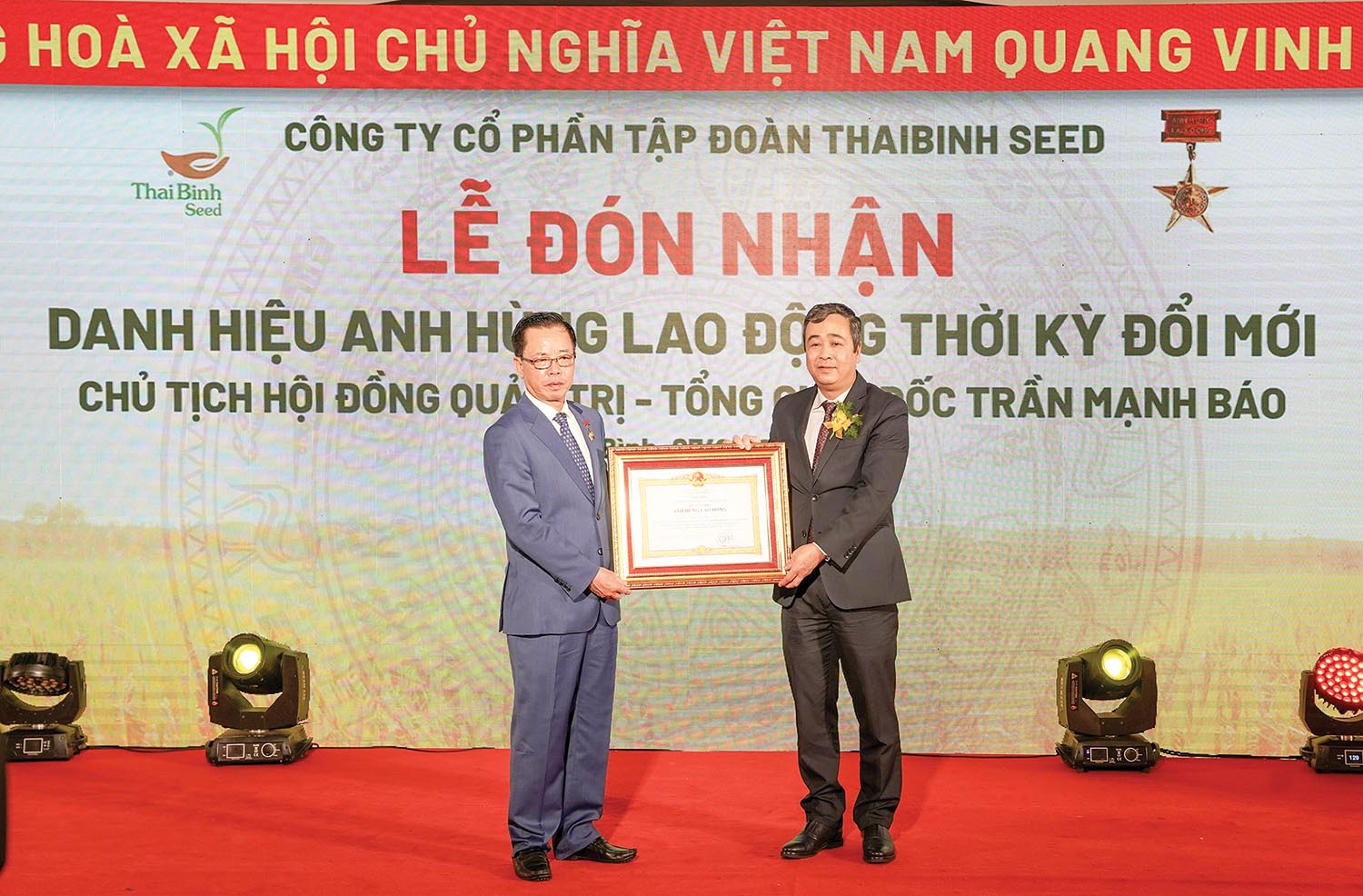 doanh nhân Trần Mạnh Báo (bên trái) đón nhận danh hiệu cao quý Anh hùng Lao động thời kỳ đổi mới