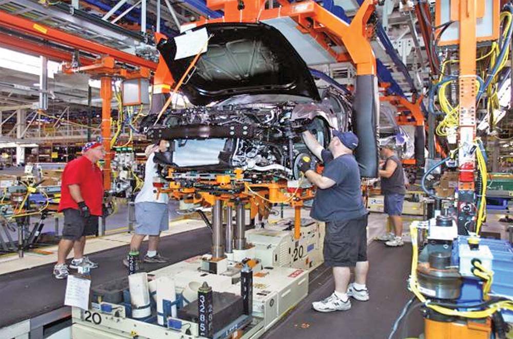 Công nhân làm việc trong dây chuyền lắp ráp ô tô của General Motors (bang Michigan, Mỹ) 	Ảnh: AFP