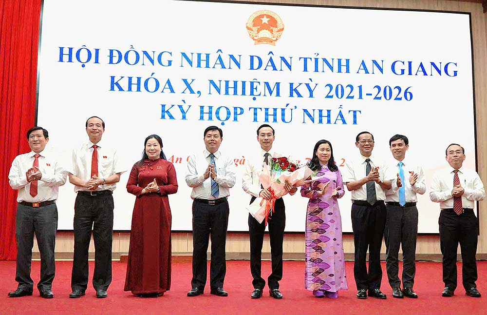 Bí thư Tỉnh ủy An Giang Nguyễn Tiến Hải (thứ 4 từ trái qua) tặng hoa cho các thành viên thường trực HĐND tỉnh