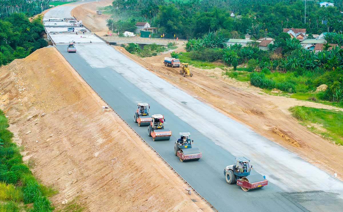 Hạ tầng được đầu tư đồng bộ Trong chiến lược phát triển kinh tế - xã hội của khu vực miền Trung, hạ tầng luôn giữ vai trò tiên quyết, nhất là sau khi sáp nhập yêu cầu về kết nối lại càng trở nên bức thiết. Chính vì vậy, các tỉnh miền Trung đang tăng tốc đầu tư hạ tầng giao thông đồng bộ, hiện đại, tạo nền tảng kết nối liên vùng, thúc đẩy phát triển kinh tế - xã hội. Minh chứng rõ nét đó là hàng loạt Dự án giao thông trọng điểm đã và đang được triển khai mạnh mẽ tại miền Trung như các tuyến cao tốc Đà Nẵng - Quảng Ngãi, Quảng Ngãi - Hoài Nhơn, Cam Lộ - La Sơn, Nha Trang - Cam Lâm… không chỉ rút ngắn thời gian di chuyển giữa các địa phương mà còn mở ra không gian phát triển mới dọc hành lang kinh tế ven biển miền Trung. TS. Phan Thị Sông Thương (Viện Khoa học xã hội vùng Trung Bộ) cho biết, hiện nay, hạ tầng giao thông ở miền Trung đã đầu tư cơ bản thông suốt. Hiện các tuyến kết nối liên tỉnh như đường ven biển đã được đầu tư tạo thuận lợi phát triển kinh tế. Đặc biệt, sau khi hợp nhất, việc đầu tư hạ tầng giao thông được chú trọng, các vướng mắc được tháo gỡ và tránh đầu tư dàn trải. Việc phát triển các cao tốc Bắc - Nam mở ra nhiều cơ hội để các tỉnh bứt phá, nhất là trong lĩnh vực logistics. Đơn cử, tại công trường Dự án Đầu tư xây dựng công trình đường bộ cao tốc Bắc - Nam, đoạn Quảng Ngãi - Hoài Nhơn có tổng mức đầu tư hơn 20.400 tỷ đồng, hàng nghìn công nhân và thiết bị đang hết sức khẩn trương chạy đua với thời gian, quyết tâm hoàn thành Dự án trước ngày 31/12/2025. Đại diện Tập đoàn Đèo Cả (nhà thầu đứng đầu liên danh) cho biết, trên công trường đang triển khai 50/50 mũi thi công với 3.000 nhân sự và 1.100 thiết bị. Tổng sản lượng đến nay đạt khoảng 11.500 tỷ đồng, tương đương 86% tổng khối lượng. Các gói thầu đều đang được triển khai đồng bộ. Tập đoàn xác định rõ đây là Dự án đặc biệt quan trọng, có ý nghĩa chiến lược với khu vực miền Trung và cả nước. Vì vậy, bên cạnh việc đẩy nhanh tiến độ, chúng tôi đặc biệt chú trọng yếu tố an toàn và chất lượng công trình. Dự án thành phần 3 thuộc Dự án Xây dựng đường bộ cao tốc Khánh Hòa - Buôn Ma Thuột giai đoạn I cũng đang hết sức khẩn trương. Với quyết tâm cao, các nhà thầu phấn đấu hoàn thành Dự án vào cuối tháng 11 năm nay. Ông Trần Văn Hồng, Phó chỉ huy công trường gói thầu 2 cho biết, gói thầu của đơn vị có tổng chiều dài 15,5 km. Sau khi vượt qua những khó khăn ban đầu về giải phóng mặt bằng, đến nay đã đạt khoảng 72% khối lượng, đảm bảo tiến độ tổng thể. Trong khi đó, sau gần 2 năm nỗ lực triển khai, Dự án Xây dựng đường cao tốc đoạn Hòa Liên - Túy Loan qua Đà Nẵng, với tổng vốn 2.113 tỷ đồng, đã cơ bản hoàn thành và tổ chức thông xe kỹ thuật. Ông Lê Thanh Bình, Phó giám đốc Ban Quản lý Dự án đường Hồ Chí Minh (chủ đầu tư) cho hay, Dự án đã hoàn thành cơ bản 11,5 km tuyến chính cao tốc; hai đường gom hai bên tuyến cao tốc cũng đang triển khai để hoàn thành trong năm 2025. Mới đây, UBND TP. Đà Nẵng có quyết định phê duyệt đầu tư Dự án Tuyến đường kết nối đường Vành đai phía Tây đến cao tốc La Sơn - Túy Loan. Dự án có tổng mức đầu tư hơn 1.600 tỷ đồng, thời gian thực hiện từ năm 2025 đến năm 2028. Tuyến đường có điểm đầu giao với tuyến đường Vành đai phía Tây thuộc địa phận xã Bà Nà; điểm cuối giao với tuyến nhánh hoàn trả Nam hầm Hải Vân - Túy Loan.  Theo UBND TP.Đà Nẵng, việc đầu tư xây dựng tuyến đường này sẽ góp phần hoàn thiện mạng lưới giao thông chính theo đồ án quy hoạch chung TP. Đà Nẵng đến năm 2030, tầm nhìn 2045. Dự án cũng giúp phát huy hiệu quả đầu tư các công trình trọng điểm, kết nối Khu công nghệ thông tin tập trung, Khu công nghệ cao, Khu công nghiệp Hòa Ninh… với các trục giao thông chính của thành phố, đáp ứng nhu cầu vận tải trong tương lai, đặc biệt là vận chuyển hàng hóa từ Cảng Liên Chiểu đi về phía Nam, phía Tây thành phố và ngược lại. Bên cạnh các tuyến cao tốc, cảng biển cũng được các tỉnh miền Trung chú trọng đầu tư như Cảng nước sâu Dung Quất (Quảng Ngãi), Cảng Cam Ranh, Vân Phong (Khánh Hoà) hay Bến cảng Liên Chiểu đang được đầu tư… Sau khi Hợp phần A - phần cơ sở dùng chung, Dự án Bến cảng Liên Chiểu được khởi công cuối năm 2022 và dự kiến hoàn thành vào cuối năm 2025. Qua đó, kỳ vọng Dự án không chỉ là một công trình hạ tầng lớn, mà còn là biểu tượng cho tham vọng phát triển kinh tế biển và logistics của Đà Nẵng nói riêng, miền Trung nói chung; có thể trở thành cảng trung chuyển quốc tế tầm vóc Đông Nam Á. Vừa qua, UBND TP. Đà Nẵng đã chấp thuận chủ trương đầu tư, Dự án xây dựng tổng thể Bến cảng container Liên Chiểu với tổng vốn đầu tư dự kiến hơn 45.000 tỷ đồng. Dự án hướng đến mục tiêu hình thành cảng container hiện đại, tiêu chuẩn cảng xanh, cảng trung chuyển quốc tế.  Theo Cục hàng hải và Đường thủy Việt Nam, Bến cảng Liên Chiểu được định hướng trở thành một cảng cửa ngõ quốc tế, thu hút các hãng vận tải, logistics lớn trên thế giới. Đáng chú ý, trong tương lai, khi cảng Liên Chiểu hình thành sẽ gắn liền với Khu thương mại tự do Đà Nẵng, tạo điều kiện thuận lợi để Đà Nẵng trở thành trung tâm trung chuyển hàng hóa của khu vực và quốc tế, góp phần thu hút mạnh mẽ các dòng vốn đầu tư vào Thành phố. Đây cũng là lý do việc đầu tư các bến cảng Liên Chiểu nhận được sự quan tâm lớn của các nhà đầu tư tên tuổi trong nước và trên thế giới trong lĩnh vực khai thác cảng biển, logistics và vận tải biển. Tại Quảng Trị, Dự án đầu tư xây dựng Khu bến cảng Mỹ Thủy, do Công ty cổ phần Liên doanh Cảng Quốc tế Mỹ Thủy làm chủ đầu tư (MTIP) dự kiến sẽ hoàn thành bến số 1 vào tháng 11/2025 và bến số 2 vào tháng 3/2026. Dự án có tổng diện tích 685 ha; quy mô 10 bến; bảo đảm tiếp nhận tàu có trọng tải đến 100.000 tấn, tổng vốn đầu tư 15.000 tỷ đồng. Trong khi đó Dự án Cảng hàng không Quảng Trị với tổng mức đầu tư hơn 5.800 tỷ đồng đến nay đã hoàn thành hạng mục sân đỗ máy bay, dự kiến đưa vào khai thác vào năm 2026. Sân bay Quảng Trị sau khi đưa vào hoạt động, khai thác sẽ hình thành một tổ hợp hàng không tầm cỡ khu vực và quốc tế trên diện tích quy hoạch khoảng 3.400 ha, gồm Khu đô thị -Thương mại dịch vụ - Logistic - Công nghiệp bán dẫn và các ngành công nghiệp công nghệ cao. Phát triển trục ngang Đặc biệt, trong thời gian tới, đường sắt cao tốc Bắc - Nam được đầu tư chạy qua các tỉnh miền Trung sẽ mở ra nhiều cơ hội và không gian phát triển hơn nữa. Để chuẩn bị cho việc này, các tỉnh đang xây dựng các khu tái định và giải phóng mặt bằng phục vụ Dự án. Theo ông Nguyễn Minh Huy, Giám đốc Ban quản lý Dự án đầu tư xây dựng các công trình giao thông và nông nghiệp Đà Nẵng cho biết, Thành phố đã khởi công xây dựng Khu tái định cư phục vụ Dự án Đường sắt tốc độ cao trục Bắc - Nam. Tuyến đường sắt tốc độ cao trục Bắc - Nam đi qua địa phận Đà Nẵng có chiều dài 116 km, dự kiến ảnh hưởng đến hơn 2.100 hộ dân. Để giải quyết vấn đề tái định cư, Đà Nẵng có kế hoạch xây dựng 35 khu tái định cư, với tổng diện tích 211 ha, tạo ra hơn 3.300 lô đất tái định cư. Tổng chi phí cho công tác này ước tính hơn 3.600 tỷ đồng. Không những vậy, Đà Nẵng thành lập 2 tổ công tác đặc trách nhằm xử lý các vấn đề liên quan đến công tác bồi thường, đền bù, hỗ trợ tái định cư đối với Dự án đường sắt tốc độ cao chạy qua địa phận Thành phố. Ngoài việc phát triển trục dọc, các tỉnh thành ở miền Trung cũng đang chú trọng đầu tư các Dự án cao tốc theo trục ngang để khai thác tiềm năng, lợi thế của địa phương. Theo Quy hoạch mạng lưới đường bộ thời kỳ 2021 - 2030, tầm nhìn đến năm 2050, cao tốc Quảng Ngãi - Kon Tum kết nối tuyến cao tốc Bắc - Nam phía Đông và tuyến cao tốc Bắc -  Nam phía Tây, có chiều dài khoảng 136 km, quy mô 4 làn xe, tiến trình đầu tư trước năm 2030. Dự án này cũng vừa được Thủ tướng Chính phủ bổ sung vào danh mục Dự án và kiện toàn Ban chỉ đạo Nhà nước các công trình, Dự án quan trọng quốc gia, trọng điểm ngành giao thông vận tải. Ngoài ra, tại Gia Lai, UBND tỉnh đang chỉ đạo quyết liệt công tác chuẩn bị để kịp tiến độ khởi công Dự án cao tốc Quy Nhơn - Pleiku thành phần 1 trong tháng 10/2025, khởi công Dự án thành phần 2 trong tháng 12/2025 và khởi công Dự án thành phần 3 trong tháng 11/2025. Dự án cao tốc Quy Nhơn - Pleiku có tổng chiều dài khoảng 125 km với tổng mức đầu tư Dự án hơn 43.700 tỷ đồng. Theo lãnh đạo UBND tỉnh Gia Lai, đây là công trình quan trọng bậc nhất của địa phương, rút ngắn thời gian di chuyển, kết nối giao thông giữa các vùng kinh tế, giữa vùng rừng núi và biển, tạo điều kiện thuận lợi để giao thương phát triển. Tuyến này phá thế độc đạo của Quốc lộ 19, tạo động lực phát triển kinh tế - xã hội và bảo đảm quốc phòng - an ninh. Tuyến cũng kết nối các cửa khẩu quốc tế, khu đô thị, cảng biển. n