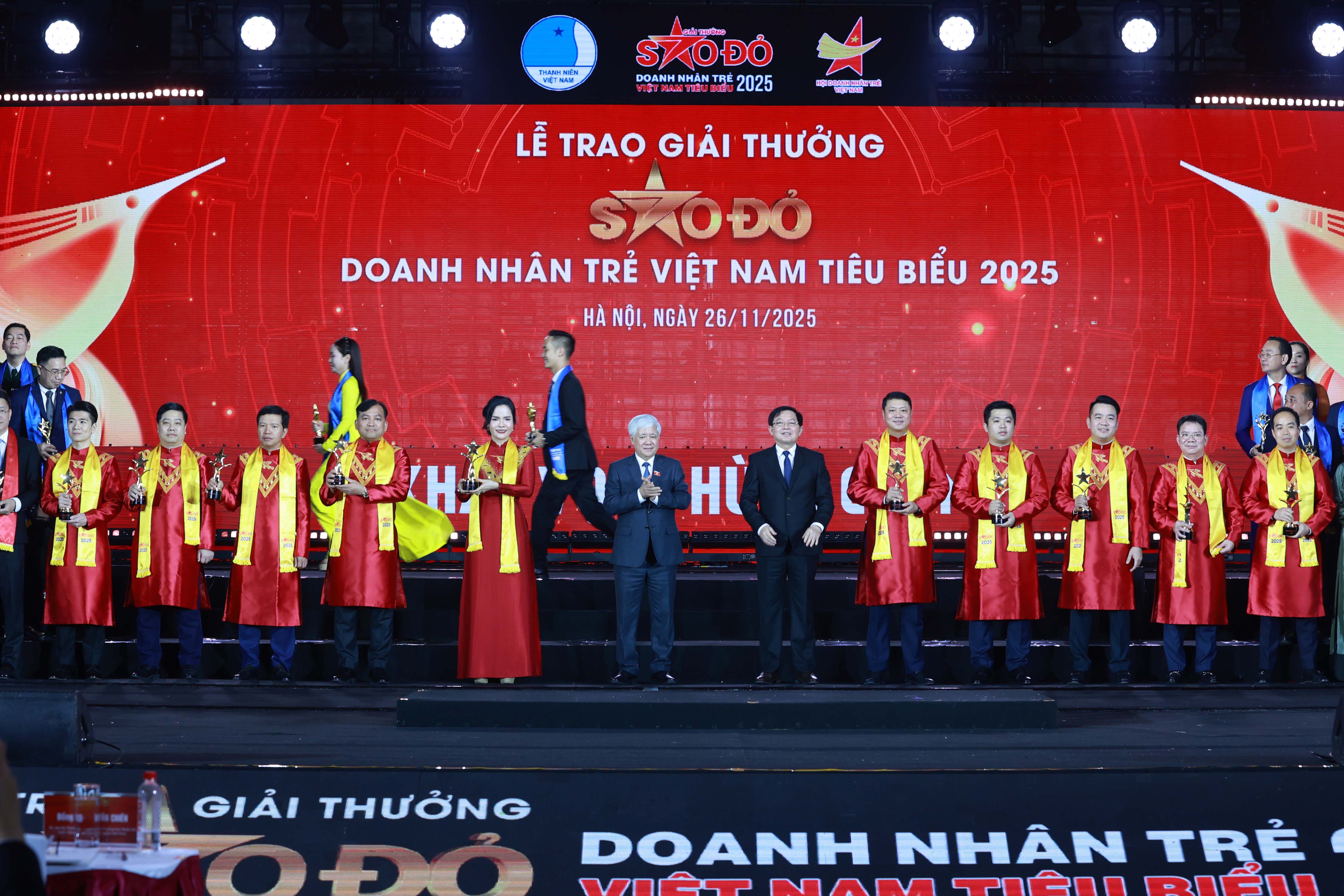 Phó Chủ tịch Thường trực Quốc hội Đỗ Văn Chiến và Phó Thủ tướng Chính phủ Hồ Quốc Dũng chụp ảnh lưu niệm cùng các doanh nhân nhận Giải thưởng Sao Đỏ 2025.