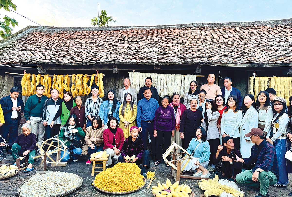 C&aacute;c nghệ nh&acirc;n tr&igrave;nh diễn v&agrave; hướng dẫn du kh&aacute;ch trải nghiệm se tơ, r&uacute;t đũi tại l&agrave;ng nghề dệt đũi Nam Cao (Ảnh: Hồ Hạ)