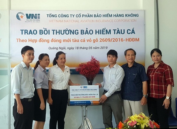 Bà Hà Thị Thu Trang - Giám đốc VNI Quảng Ngãi trao số tiền bồi thường tàu cá cho chủ tàu Võ Văn Dũng