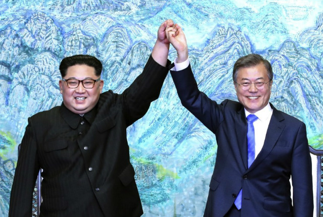 12.	Tổng thống Hàn Quốc Moon Jae-in và lãnh đạo Bắc Triều Tiên Kim Jong-un giơ cao tay sau khi ký kết tuyên bố chung tại làng biên giới Bàn Môn Điếm.