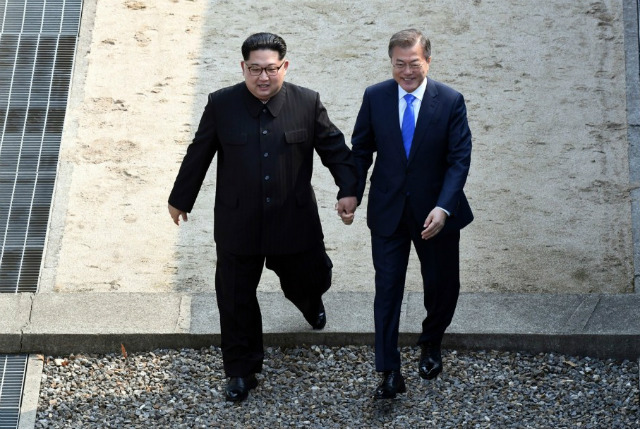 3.	Kim Jong Un và Moon Jae-in bước qua biên giới tại khu phi quân sự.