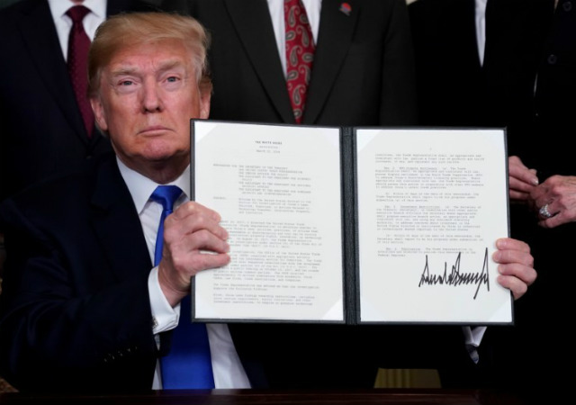 Tổng thống Mỹ Donald Trump ký lệnh đánh thuế sở hữu trí tuệ đối với sản phẩm công nghệ cao nhập khẩu từ Trung Quốc tại Nhà Trắng ngày 22/3/2018