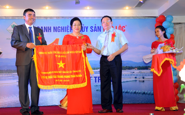 Ông Hoàng Văn Trà (bìa phải), Chủ tịch UBND tỉnh Phú Yên trao cờ thi đua của Chính phủ cho Thủy sản Đắc Lộc. Ảnh: Hà Minh