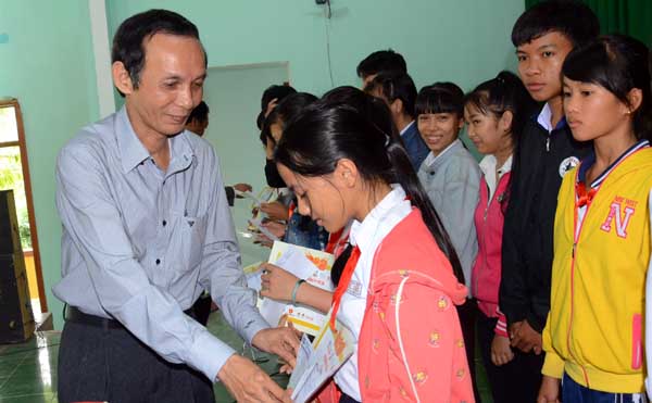 Ông Phạm Đình Tòng, Phó giám đốc Sở Kế hoạch-Đầu tư tỉnh Bình Định trao học bổng cho các em học sinh trường THCS Mỹ Tài. Ảnh: Hà Minh