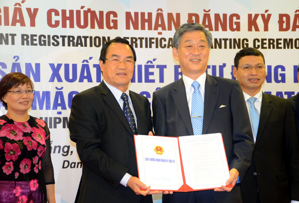 Ông Phùng Tấn Viết (bên trái) trao Giấy chứng nhận đầu tư cho nhà đầu tư