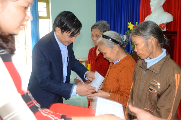 Ông Trần Văn Nua, Phó chủ tịch huyện Quế Sơn trao quà cho hộ nghèo xã Quế An