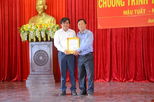 Ông Hoàng Kim Thủy (bên trái) thay mặt nhà tài trợ, Báo Đầu tư, nhận thư cảm ơn của địa phương về Chương trình tặng quà Tết cho hộ nghèo 2018.