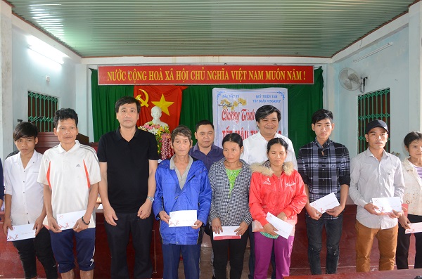 Ông Nguyễn Xuân Bắc (Chủ tịch huyện Trà Bồng, áo thun đen) đại diện chính quyền huyện trao quà cho bà con xã Trà Bùi.