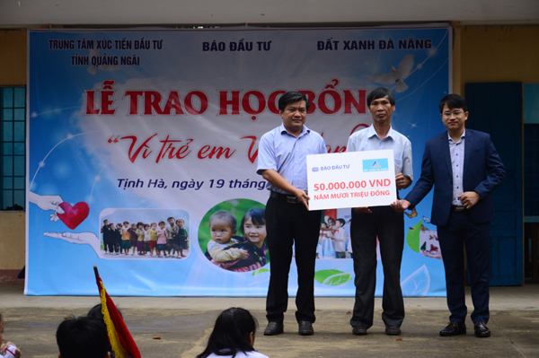 Đại diện Báo Đầu tư (bân trái) và nhà tài trợ (bên phải) trao bảng tượng trưng tại Lễ trao học bổng 