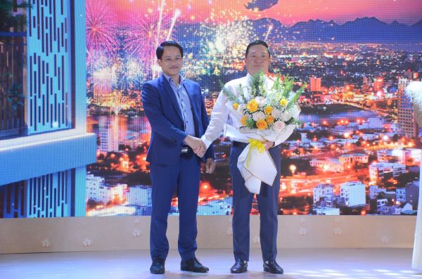 Đại diện nhà phân phối, ông Trần Xuân Thông (bên trái) trao hoa chúc mừng đại diện Chủ đầu tư tại Lễ ra mắt Dự án thành công