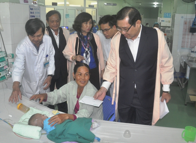 Ông Huỳnh Đức Thơ tặng quà cho gia đình các bệnh nhi đang điều trị tại Bệnh viện Phụ sản - Nhi thành phố.