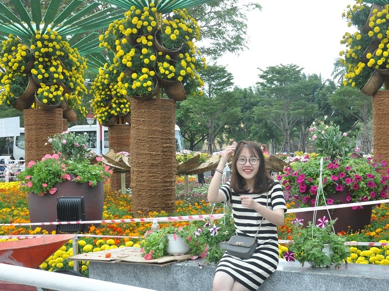 Những cô gái trẻ tạo dáng bên đường hoa Xuân ở Đà Nẵng.