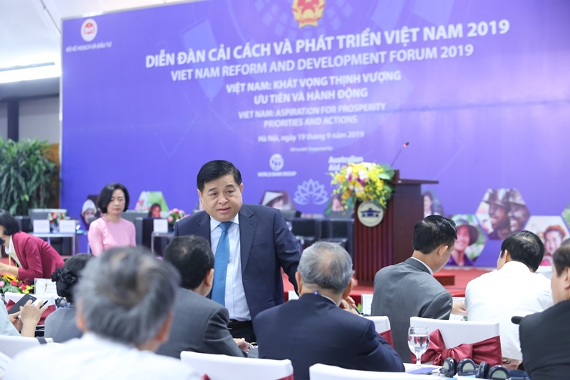 Bộ trưởng Bộ Kế hoạch và Đầu tư Nguyễn Chí Dũng trao đổi với các đại biểu bên thềm Diễn đàn. Ảnh: Hồng Hạnh.