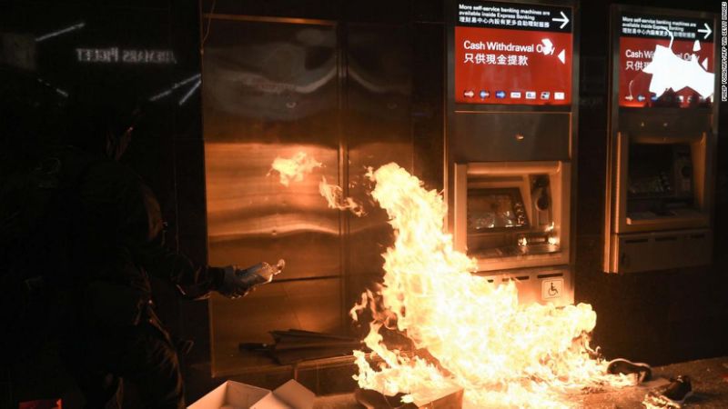 Người biểu tình châm lửa đốt máy ATM bên ngoài chi nhánh HSBC tại trung tâm Hong Kong ngày 1/1. Ảnh: AFP
