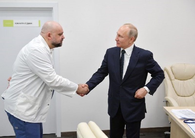Tổng thống Vladimir Putin (bìa phải) bắt tay bác sĩ Denis Protsenko trong chuyến thăm tới bệnh viện Kommunarka hôm 24/3. Ảnh: AFP