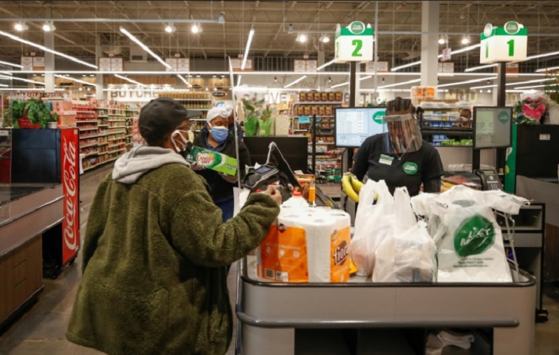 Doanh số của các cửa hàng tạp hóa tăng vọt do người tiêu dùng Mỹ có xu hướng tích trữ nhu yếu phẩm như đồ ăn, giấy vệ sinh, thuốc men… Trong ảnh: Hoạt động mua sắm tại cửa hàng thực phẩm ở thành phố Chicago. Ảnh: AFP