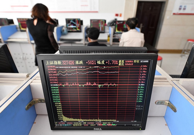 Nhà đầu tư theo dõi biến động cổ phiếu tại một đơn vị môi giới chứng khoán, tỉnh An Huy, Trung Quốc hôm 9/10. Ảnh: AFP