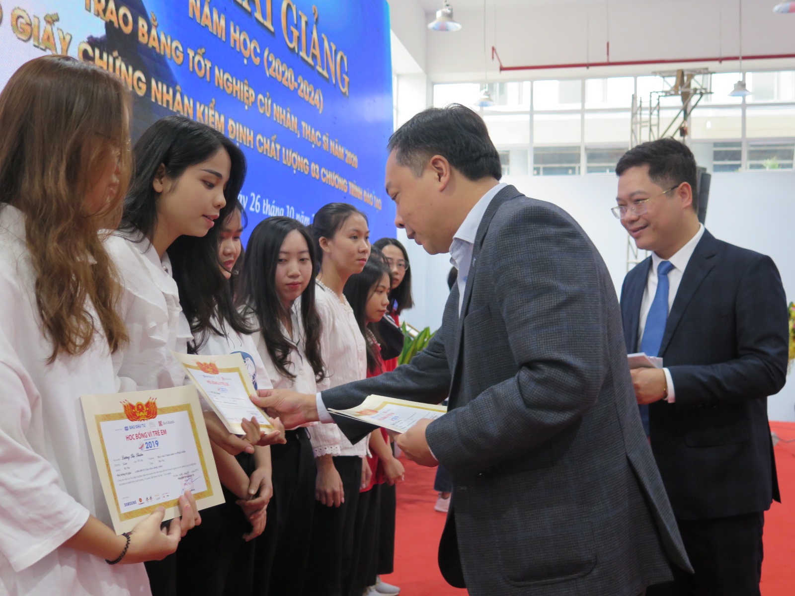 Ông Lê Trọng Minh, Tổng biên tập Báo Đầu tư trao tận tay các suất học bổng tới các em sinh viên Học viện Chính sách và Phát triển. Ảnh: Quang Đăng