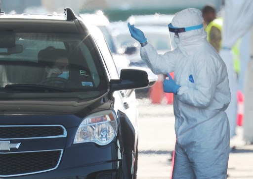 Nhân viên y tế lấy mẫu xét nghiệm Covid-19 tại bãi đỗ xe sân vận động Hard Rock, thành phố Miami Gardens, bang Florida hôm 30/3. Ảnh tư liệu: AFP