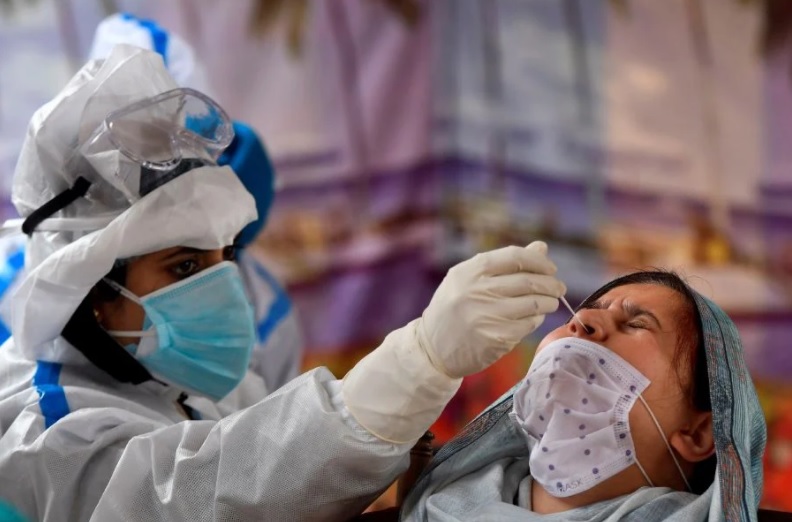 Nhân viên y tế lấy mẫu xét nghiệm Covid-19 tại một trung tâm xét nghiệm ở thành phố Srinagar, Ấn Độ. Ảnh: AFP