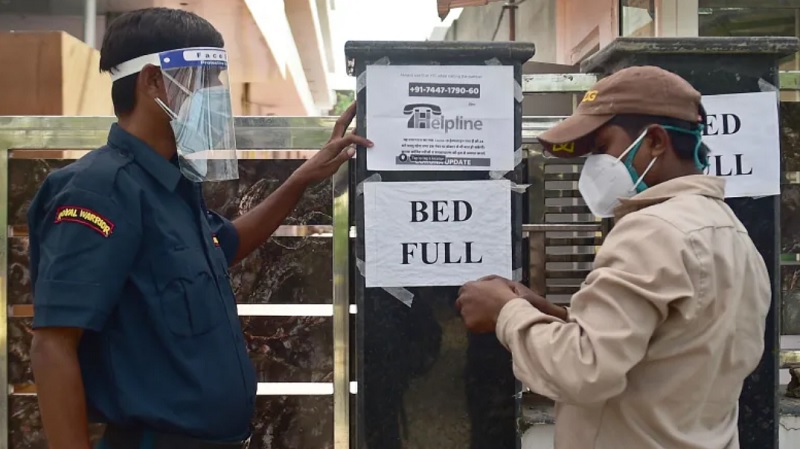 Nhân viên an ninh tại một bệnh viện tư nhân ở thành phố Allahabad, Ấn Độ thông báo hôm 22/4 tới người dân rằng bệnh viện này đã hết giường. Ảnh: AFP