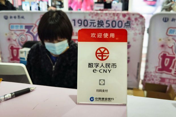 A sign for China’s new digital currency, electronic Chinese yuan (e-CNY) is displayed at a shopping mall in Shanghai on March 8, 2021. - AFP