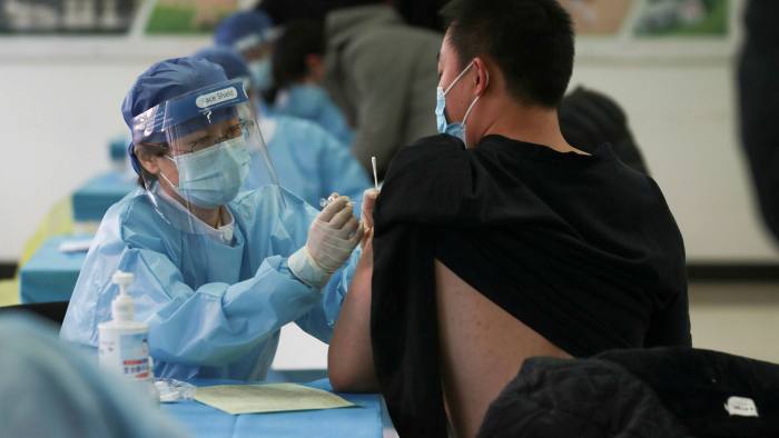 Nhân viên y tế tiêm vaccine Covid-19 tại một trung tâm y tế tạm thời ở Bắc Kinh, Trung Quốc. Ảnh: AFP