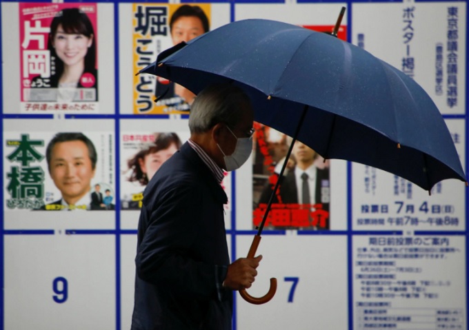 Cử tri di chuyển qua khu vực trưng bày áp phích danh sách các ứng viên cho Hội đồng Thủ đô Tokyo gần điểm bỏ phiếu vào ngày 4/7. Ảnh: Reuters