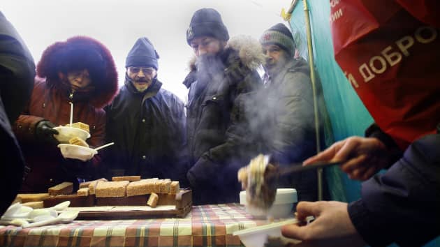 Những người vô gia cư chờ được phát thực phẩm ở thành phố Rostov-on-Don, Nga. Ảnh: AFP