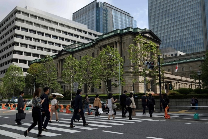 Người đi bộ qua đường gần trụ sở ngân hàng Trung ương Nhật Bản tại thủ đô Tokyo. Ảnh: AFP