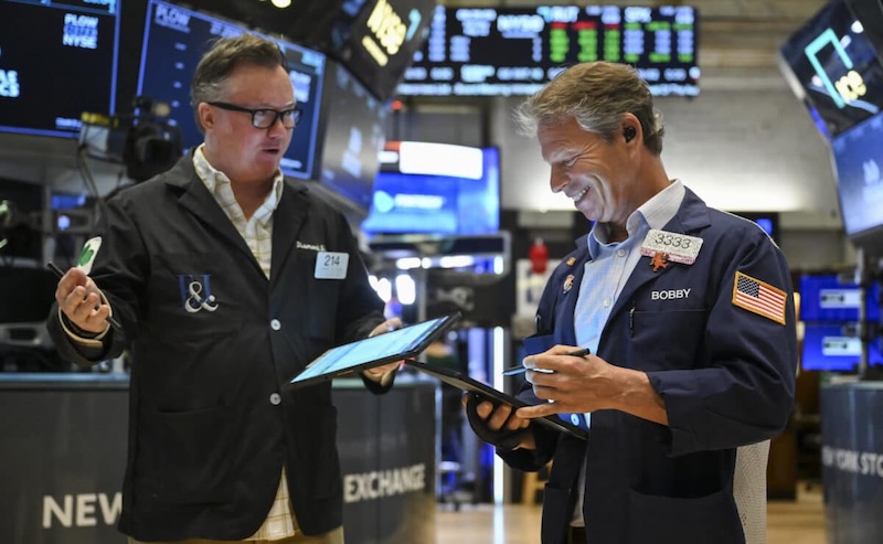 Các nhà giao dịch chứng khoán Mỹ làm việc trên sàn chứng khoán New York (NYSE). Ảnh: AFP