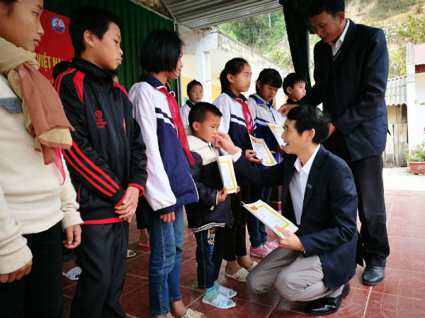 Ông Bùi Đức Hải, Phó Tổng biên tập Thường trực Báo Đầu tư trao học bổng cho học sinh.
