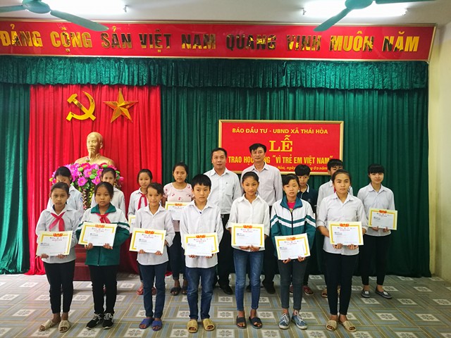 Ông Lê Trọng Minh và ông Trần Lê Minh trao học bổng, chụp ảnh lưu niệm cùng các em học sinh.
