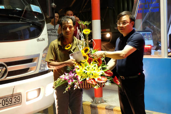 Ông Nguyễn Công Hưng, Tổng giám đốc Công ty CP Phước Tượng-Phú Gia BOT tặng hoa và quà cho chiếc xe đầu tiên nộp phí tại trạm thu phí Bắc hầm Hải Vân