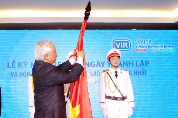 Đồng chí Uông Chu Lưu, Ủy viên Trung ương Đảng, Phó Chủ tịch Quốc hội gắn Huân chương Lao động Hạng Nhất lên lá cờ truyền thống của Báo Đầu tư