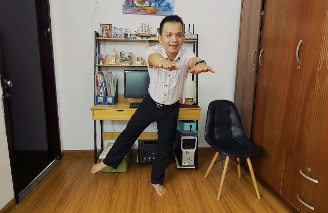 Anh Huỳnh Lê Bằng tập đứng bằng một chân tại phòng làm việc.