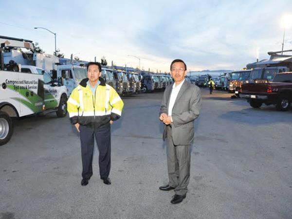 Ông David Dương đứng trước dàn xe tải CNG ra quân thực hiện gói thầu xử lý rác cho thành phố Oakland