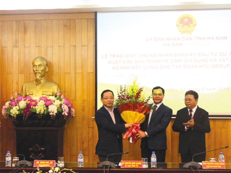 Bí thư Tỉnh ủy Hà Nam Nguyễn Đình Khang tặng hoa chúc mừng Chủ tịch Tập đoàn HTC Goup tại buổi lễ trao giấy chứng nhận đăng ký đầu tư. Ảnh: Mạnh Tùng