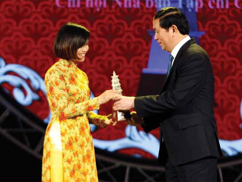 Nhà báo Trịnh Thùy Liên vinh dự đón nhận Giải A báo chí quốc gia từ Chủ tịch nước Trần Đại Quang. Ảnh: Như Ý