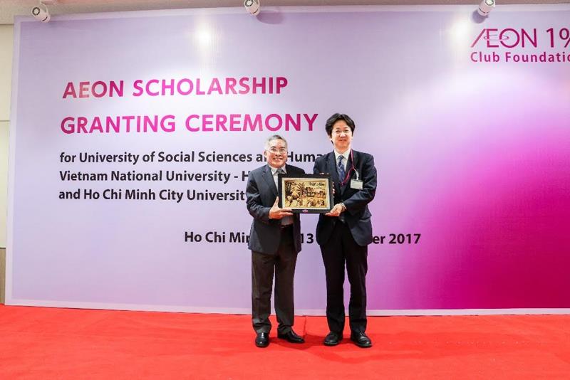 Phó Hiệu trưởng – TS. LÊ HỮU PHƯỚC đại diện trường Đại học Khoa học Xã hội và Nhân văn – Đại học Quốc gia TPHCM trao quà lưu niệm cho đại diện Qũy AEON 1% - ông Honda Yohsei.