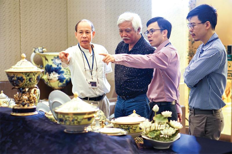 Ông Lý Ngọc Minh cùng nhà sử học Dương Trung Quốc (thứ hai từ trái sang) và hai con trai trao đổi về bộ sản phẩm phục vụ tại Tuần lễ Cấp cao APEC 2017