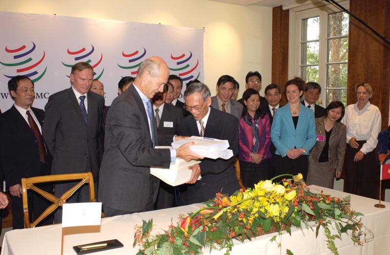 Bộ trưởng Bộ Thương mại Trương Đình Tuyển và Tổng giám đốc WTO, ông Pascal Lamy trao đổi bộ văn kiện Việt Nam gia nhập tổ chức thương mại đa phương lớn nhất hành tinh.